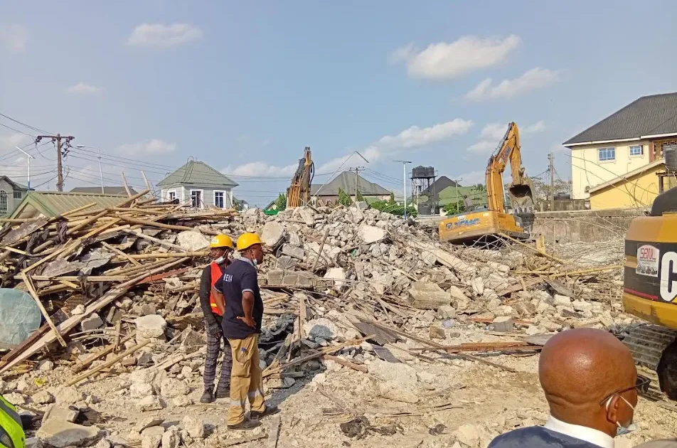 Rescue officials and excavators at the Port Harcourt building collapse site
