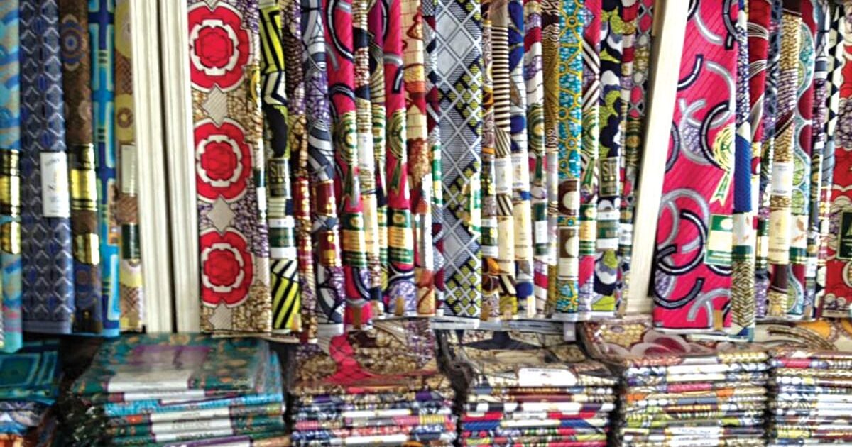 Rows of textile fabrics displayed for sale in a fabric market
