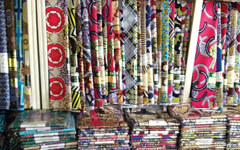 Rows of textile fabrics displayed for sale in a fabric market