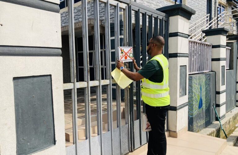 A LASEPA official places a seal notice on the gate of a hospitality facility in Lagos
