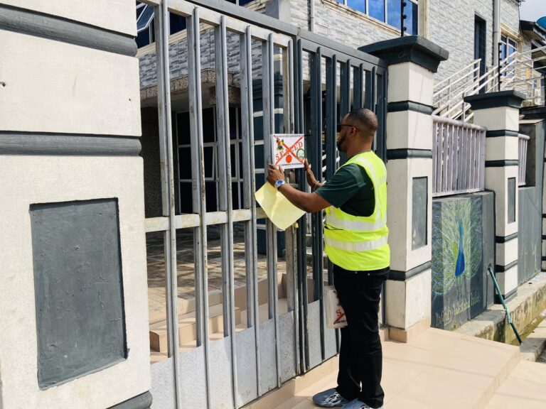 A LASEPA official places a seal notice on the gate of a hospitality facility in Lagos