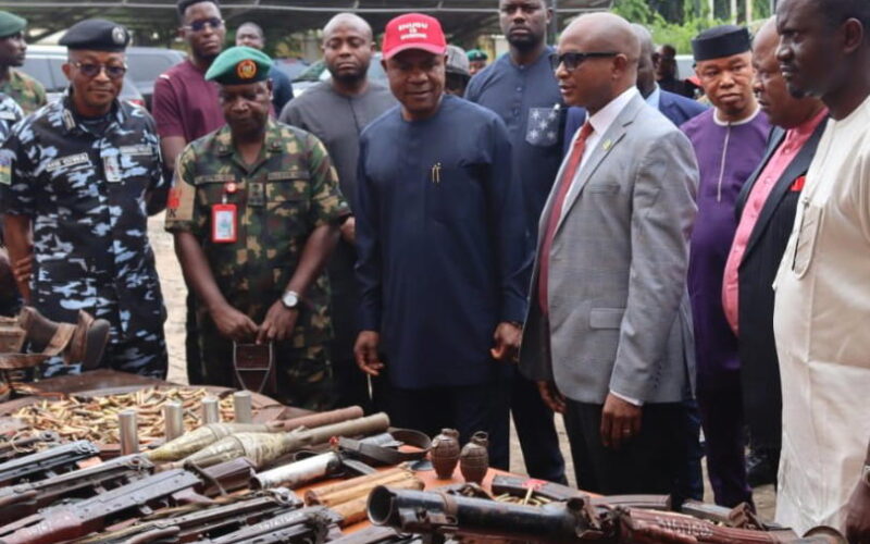 Nigerian Army and police officers at a security briefing with seized weapons in Nigeria