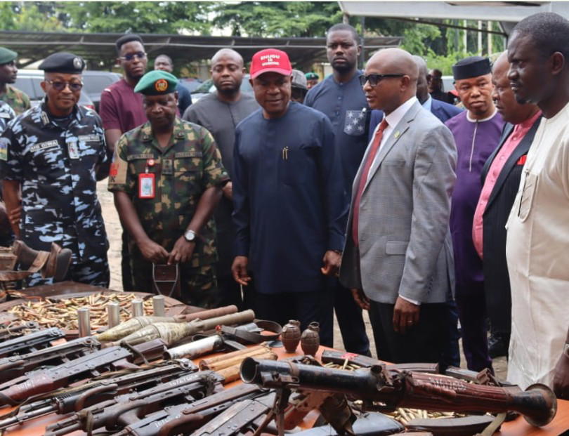 Nigerian Army and police officers at a security briefing with seized weapons in Nigeria