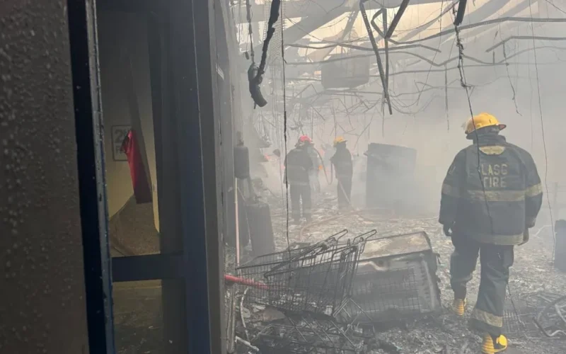 Firefighters inside the damaged Justrite Superstore section in Akowonjo Lagos