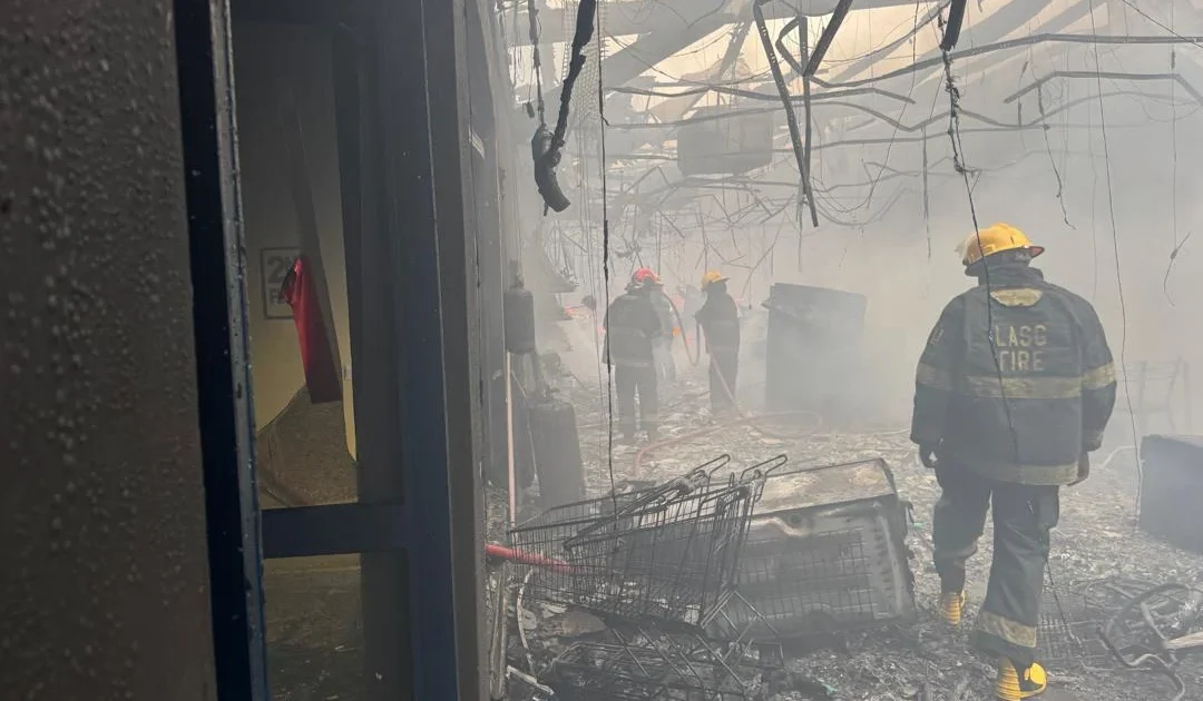 Firefighters inside the damaged Justrite Superstore section in Akowonjo Lagos