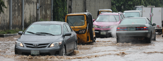 Vehicles driving through floodwater on a Lagos road