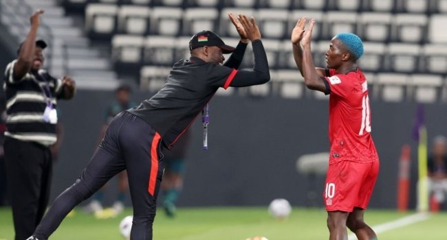 A Malawi player and coach celebrate during the WAFCON match against Nigeria