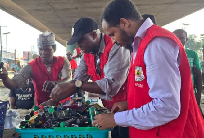 NAFDAC officers inspecting small alcoholic drink bottles during an enforcement operation