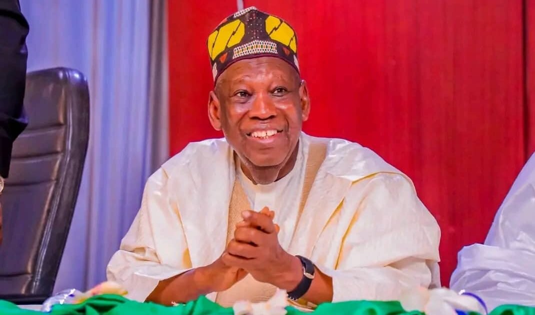 Abdullahi Ganduje seated at a political event