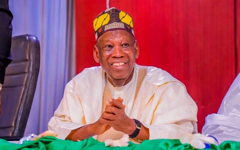 Abdullahi Ganduje seated at a political event