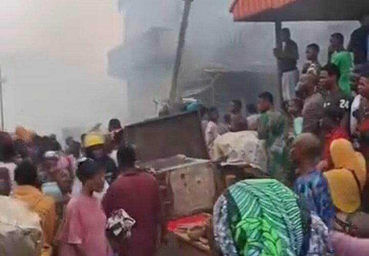 Smoke rises as people gather at the scene of the Bode Market fire in Ibadan