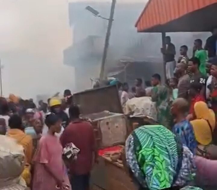 Smoke rises as people gather at the scene of the Bode Market fire in Ibadan