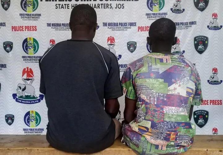 Two suspects seated before a Plateau State Police Command press backdrop