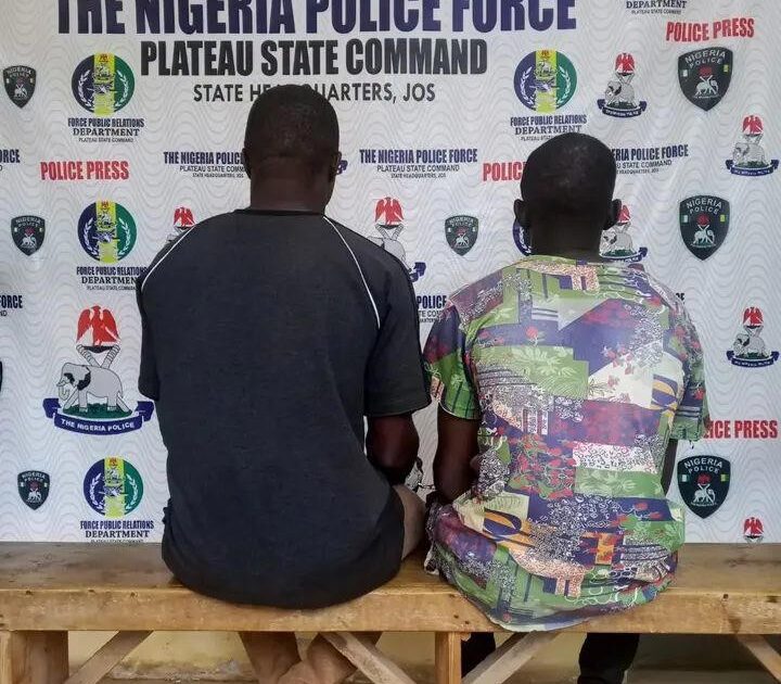 Two suspects seated before a Plateau State Police Command press backdrop