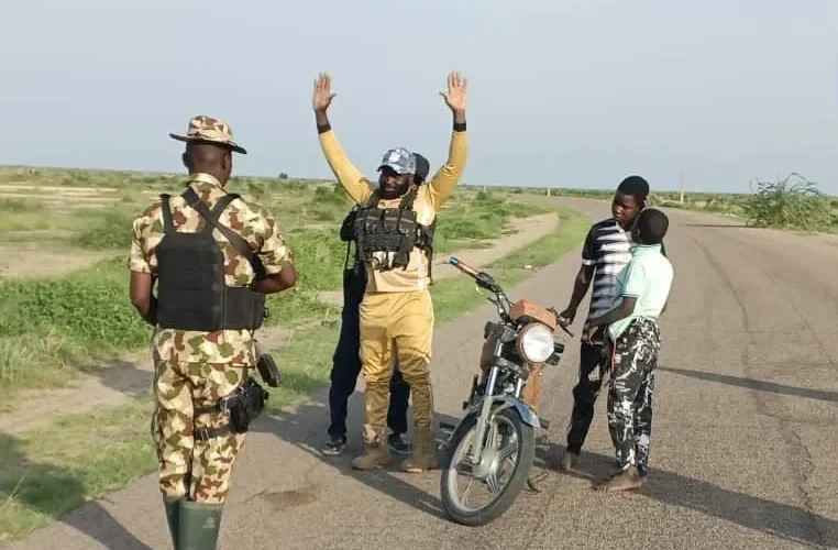 Source photo showing a surrendered ISWAP finance operative with troops in Borno