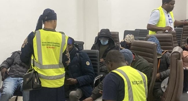 Officials attend to Nigerian returnees from South Africa after arrival in Lagos