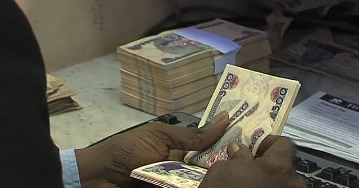 Nigerian naira notes being counted at a bank counter