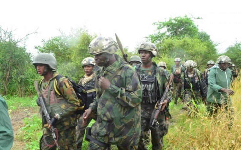 Nigerian soldiers moving through a rural area during a security operation