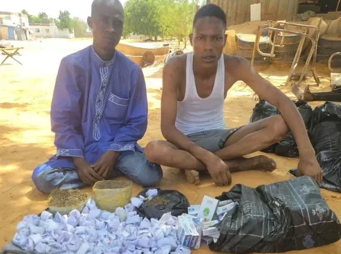 Two suspected terrorist logistics collaborators with items displayed after arrest