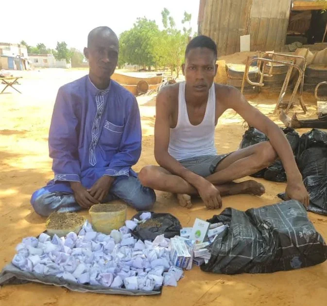 Two suspected terrorist logistics collaborators with items displayed after arrest