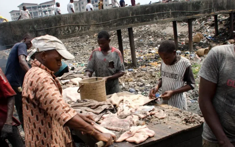 People working around an abattoir waste channel in Lagos