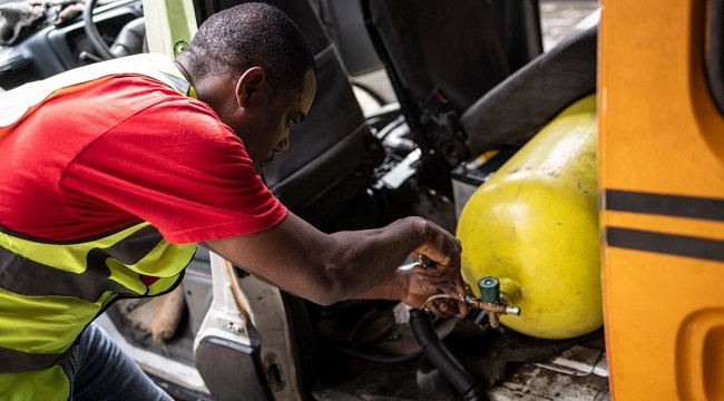 A mechanic works on a compressed natural gas conversion cylinder in a commercial vehicle in Lagos.