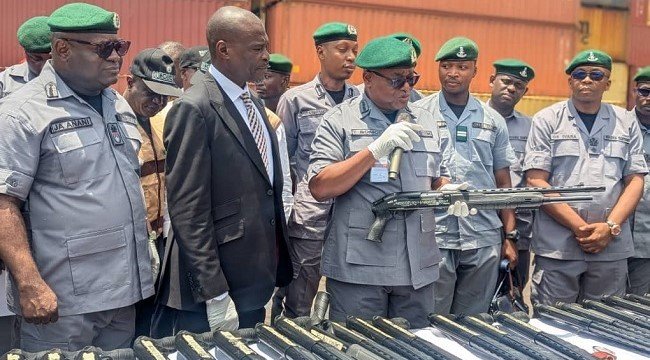 Source-origin Channels Television photo showing customs officers displaying seized rifles at Tin Can Island Port.