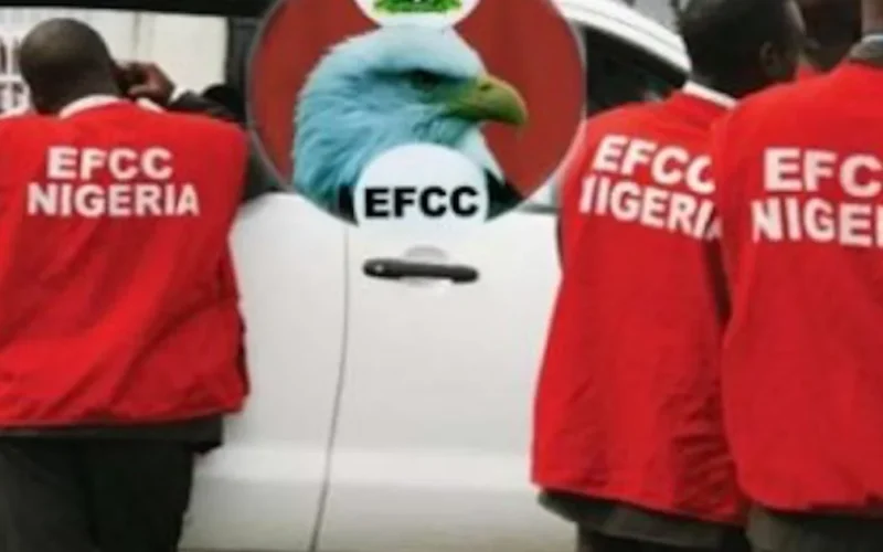 EFCC operatives beside an agency vehicle.