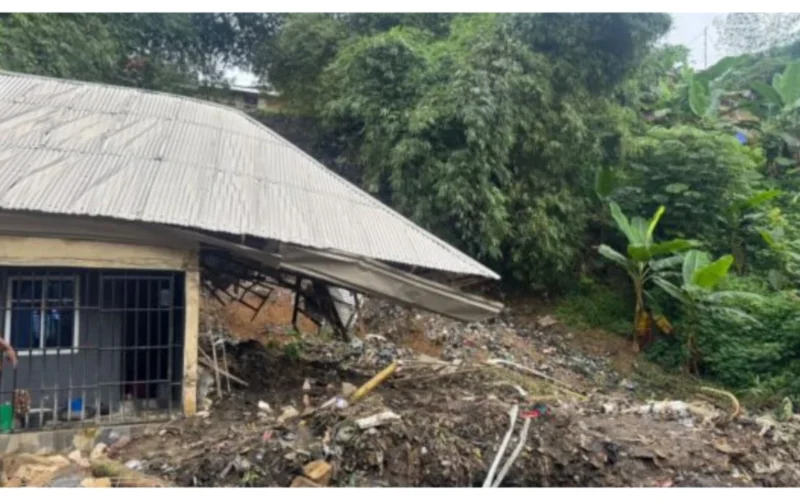 A damaged building and refuse-covered slope after the Calabar refuse dump collapse.