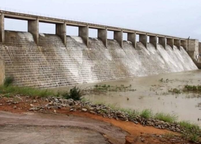 Kangimi Dam with water flowing over the spillway