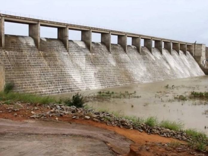 Kangimi Dam with water flowing over the spillway