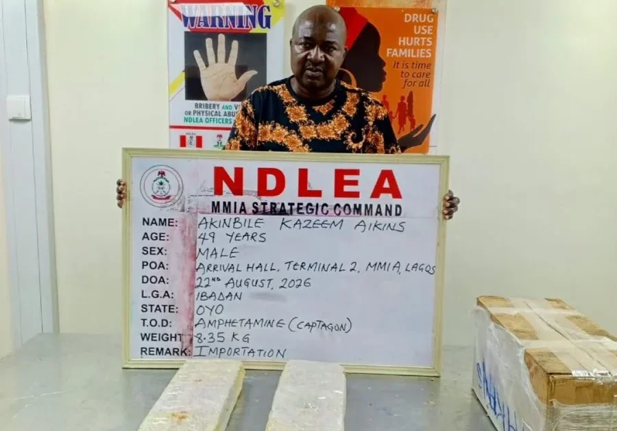 Akinbile Kazeem Aikins with NDLEA exhibit board and seized Captagon packages at MMIA Lagos
