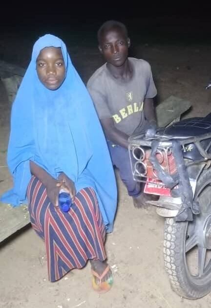A woman and a man beside a motorcycle in a nighttime photograph published with a report on the Kebbi rescue.