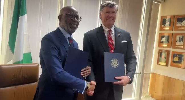 Dele Alake and Christopher Landau hold signed folders after Nigeria-US minerals pact