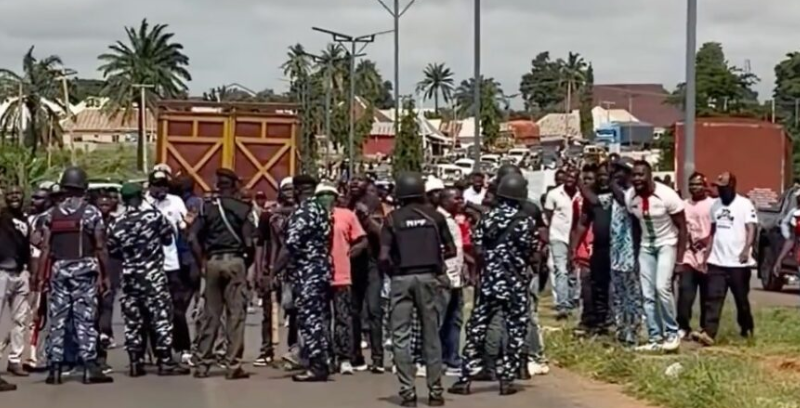 Security operatives and a crowd on a road during the blockade of Peter Obi's convoy in Benue