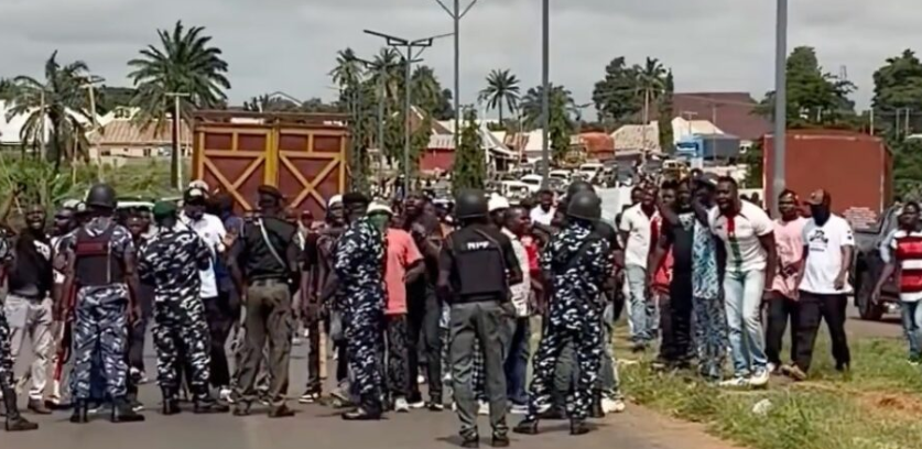 Security operatives and a crowd on a road during the blockade of Peter Obi's convoy in Benue