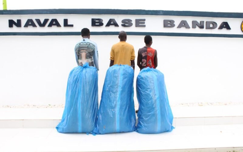 Three suspects and large blue bags at a naval base