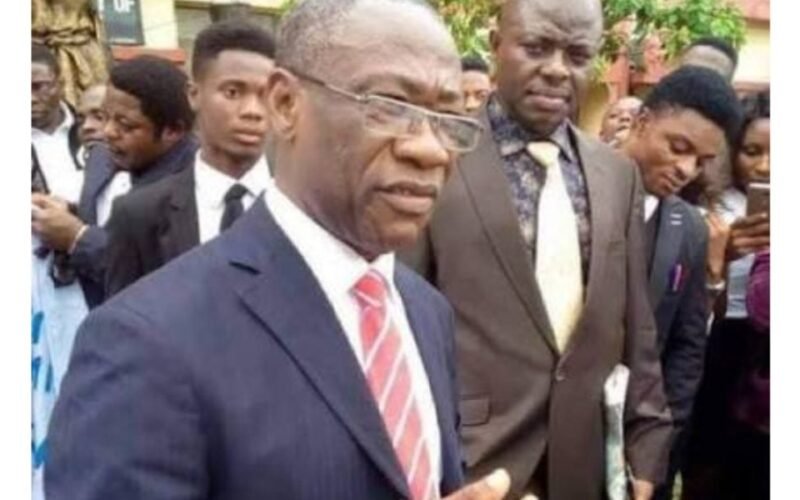 Cyril Osim Ndifon outdoors in a suit among other people