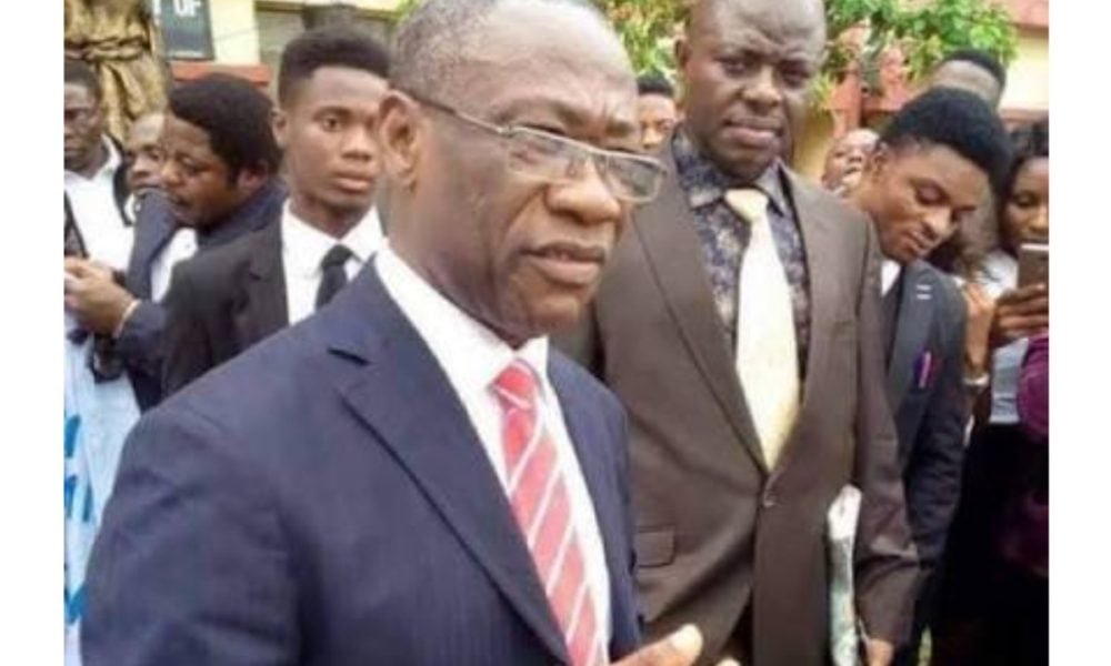 Cyril Osim Ndifon outdoors in a suit among other people