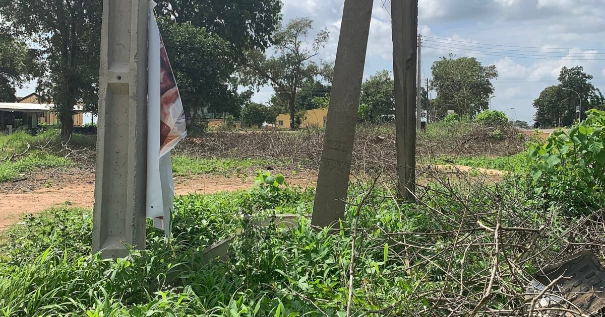 A broken concrete electricity pillar with power lines hanging loose in Nigeria