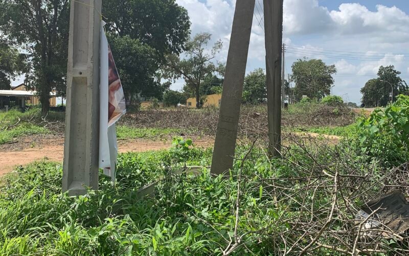 A broken concrete electricity pillar with power lines hanging loose in Nigeria