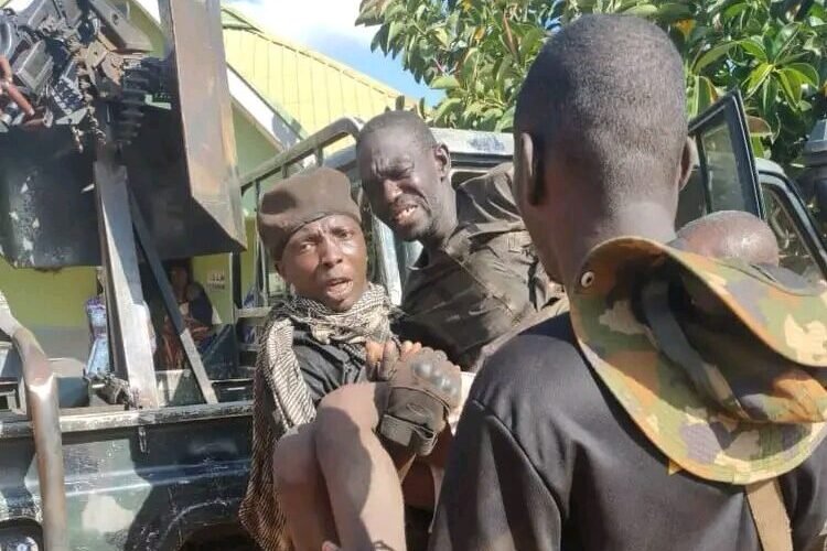 Soldiers assist a rescued kidnap victim into a military vehicle