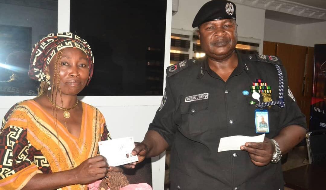 Nasarawa police commissioner presenting an insurance cheque to a beneficiary.