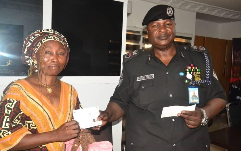 Nasarawa police commissioner presenting an insurance cheque to a beneficiary.