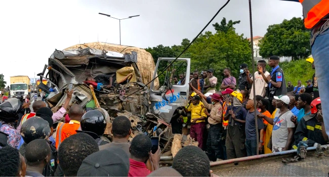 Emergency responders and bystanders at the Otedola Bridge crash scene.