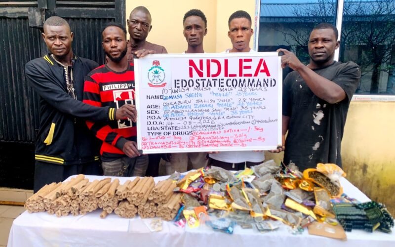 Suspected traffickers with seized drugs and an NDLEA Edo State Command board in Edo