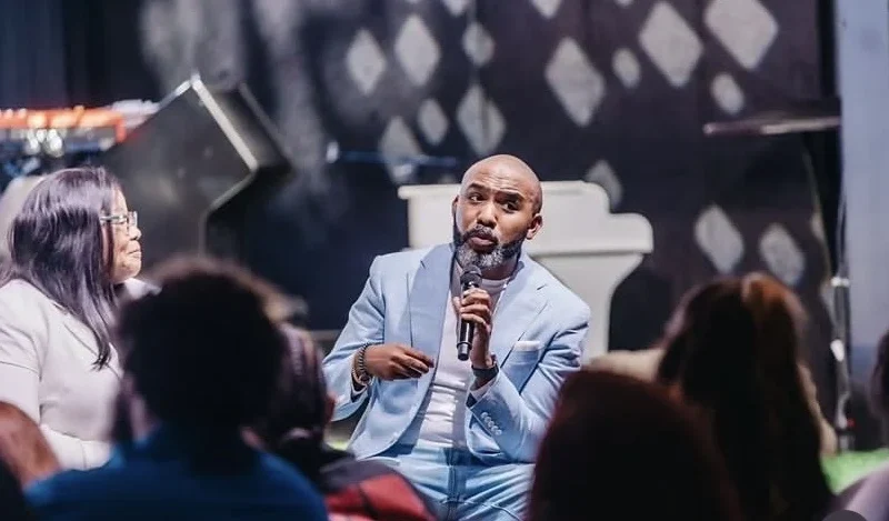 Banky W speaking with a microphone during a church event. Photograph: Banky Wellington via Punch.