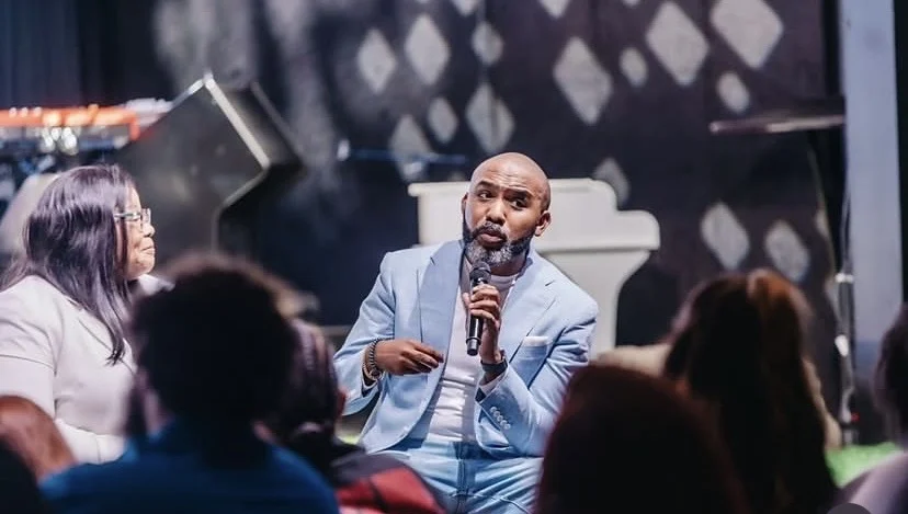 Banky W speaking with a microphone during a church event. Photograph: Banky Wellington via Punch.