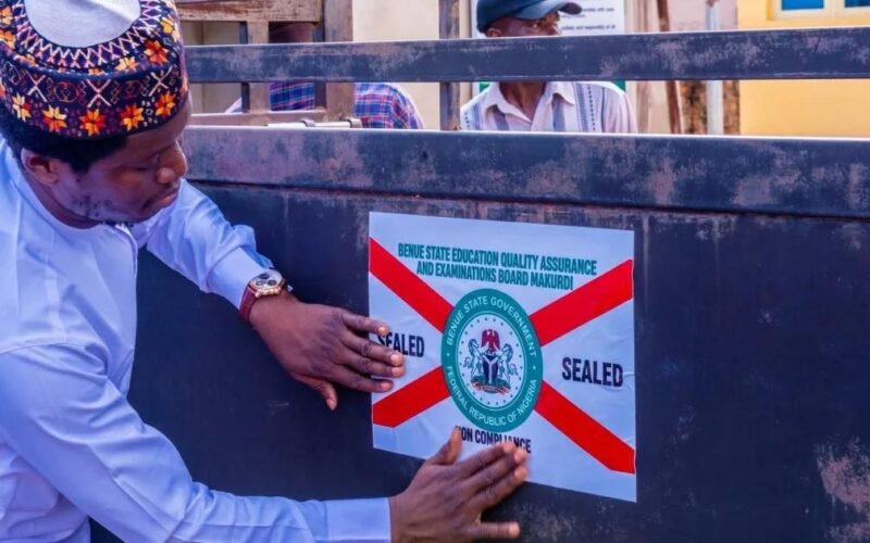 An official places a closure notice on a school gate in Benue State.