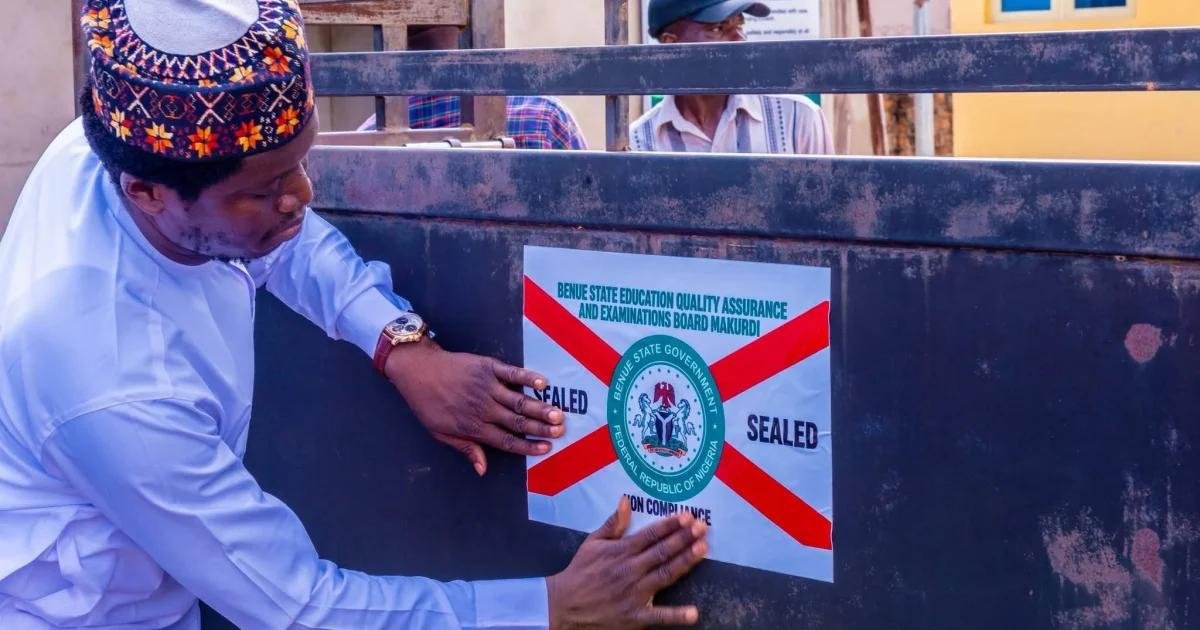 An official places a closure notice on a school gate in Benue State.